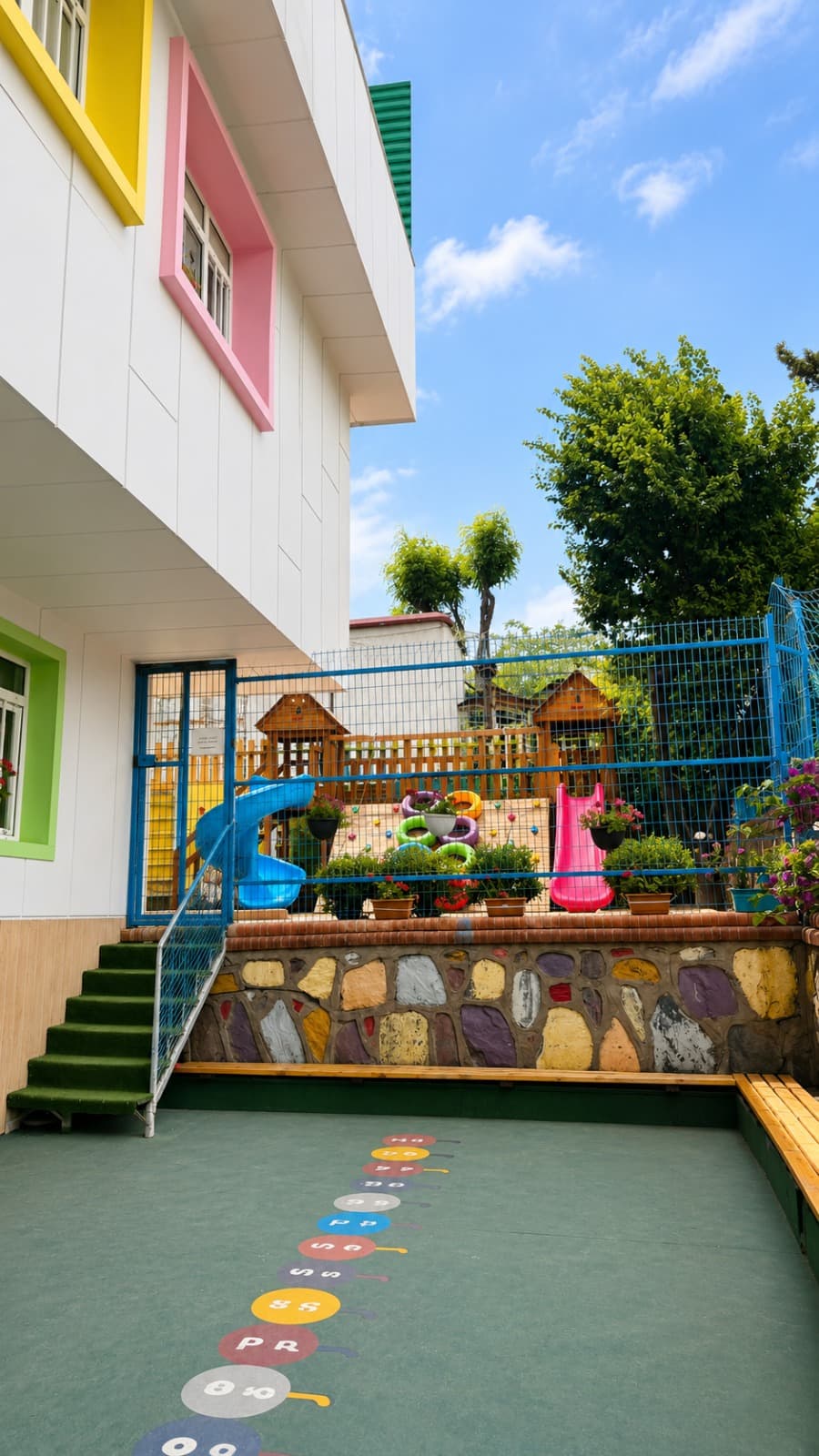 Ahşap oyun evi ve kaydırağın bulunduğu oyun bahçesi